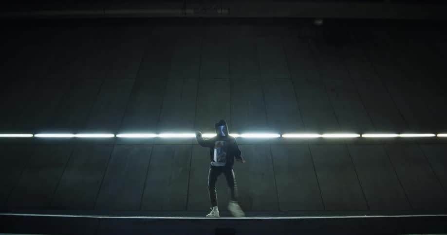 Dancer in full face mask performing outside building at night