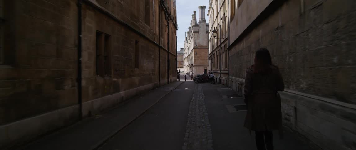 A woman walks down an alley