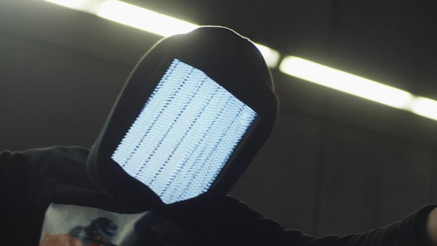 A person with a rectangle mask and a hoodie