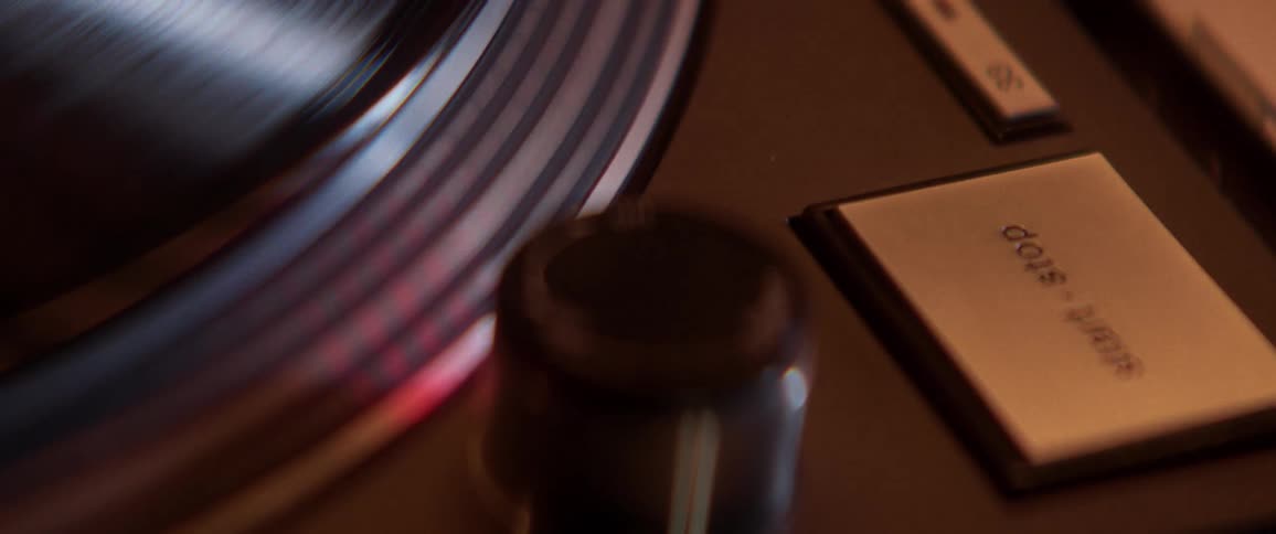 Close view of button and record spinning on record player