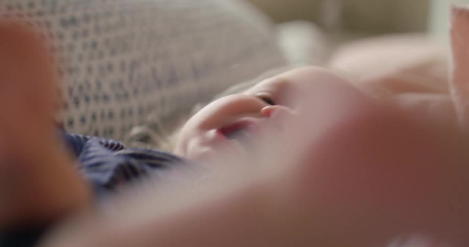 A baby rolling on a bed