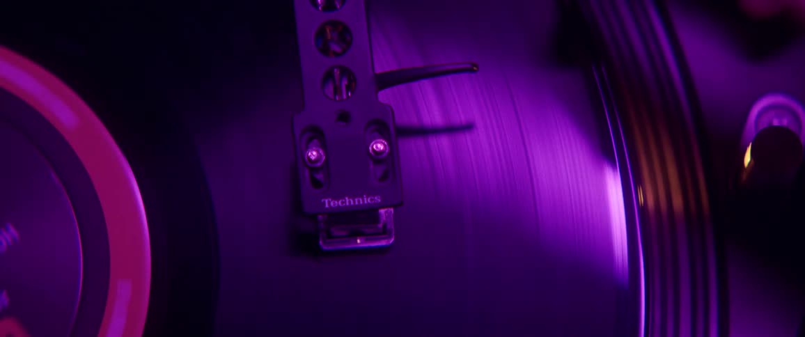 Hand removes needle from record on player