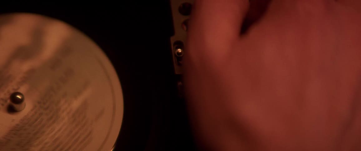 A man moves a needle on a record
