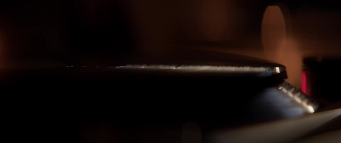 The record spinning on the player is reflecting the candle light