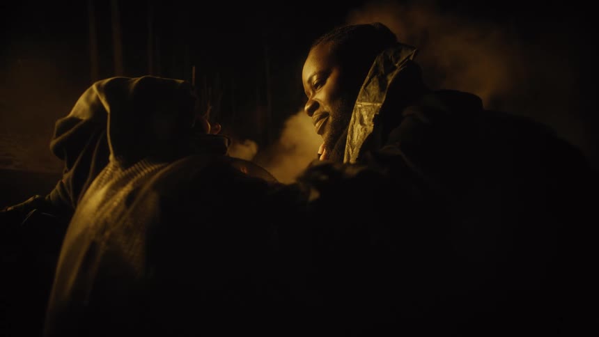 A black actor has other people touching him and rubbing his head and face