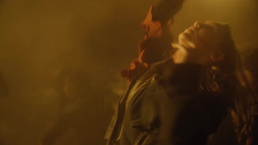 Woman in costume dances with a group of people in the mist