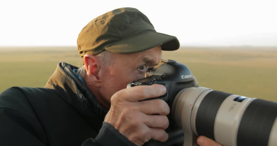 A man quickly raising a camera to capture a shot