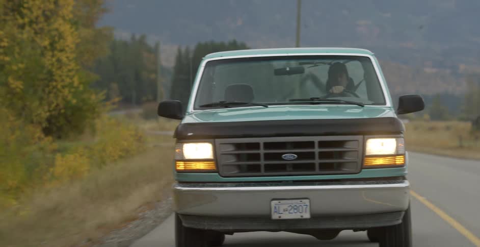 Man drives his pickup truck on a countryside road