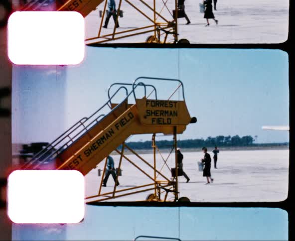 Passengers and a pilot walk across an airfield tarmac