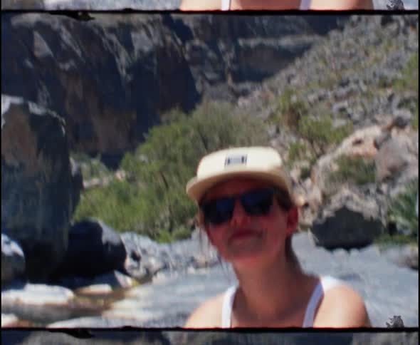 The woman sits in front of the mountains