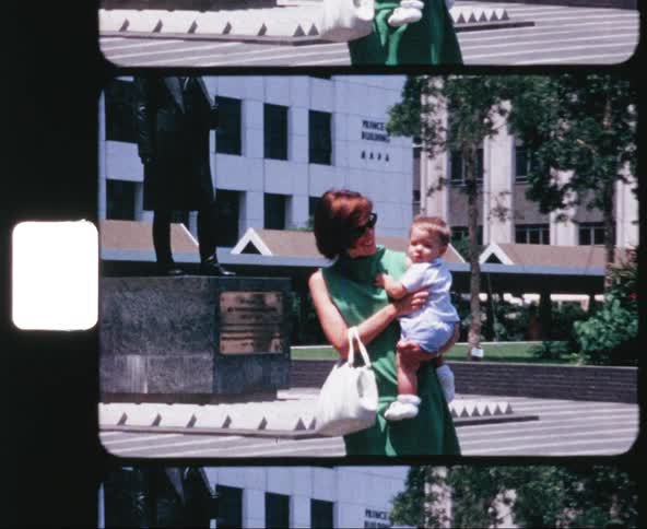 A woman walks along carrying her baby