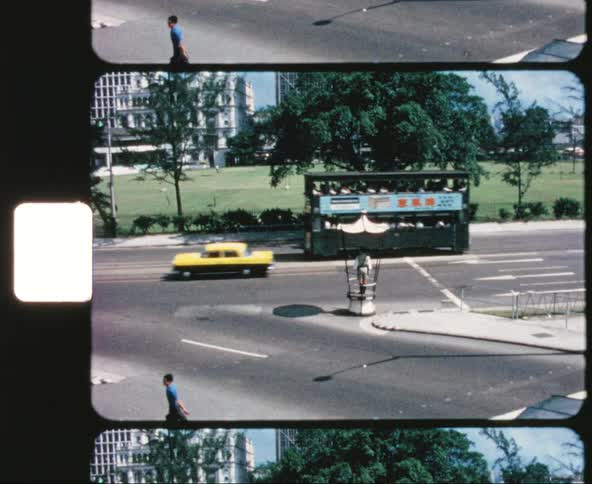 A pedestrian walks across the street as traffic moves down the road