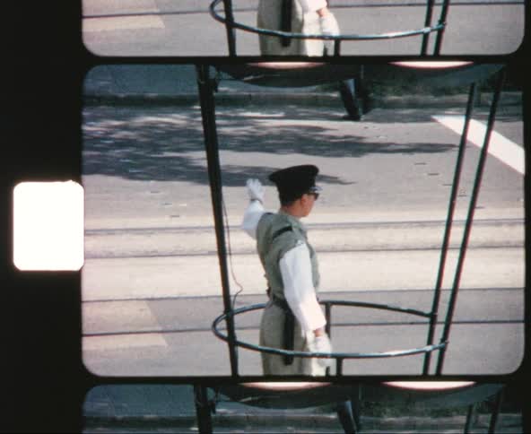 A traffic officer directs cars and pedestrians in an asian city