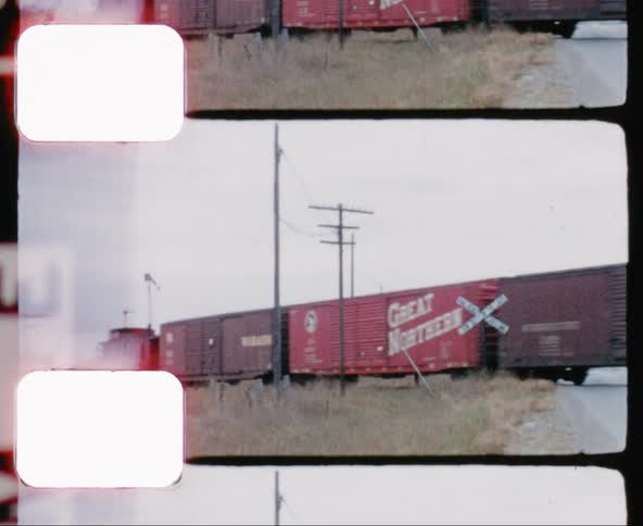 Train travels on the track over a road in a rural area