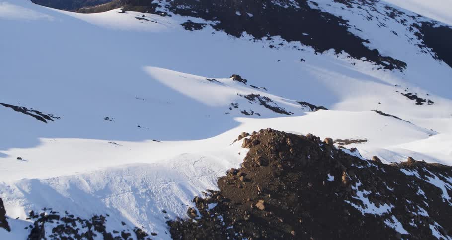 Aerial fly over of a snowy mountain slope