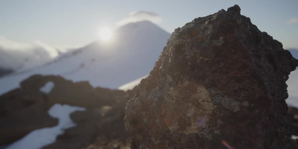 The sun over a snow covered mountain