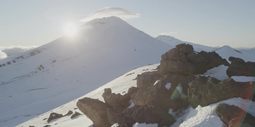 The sun is just behind a huge volcano