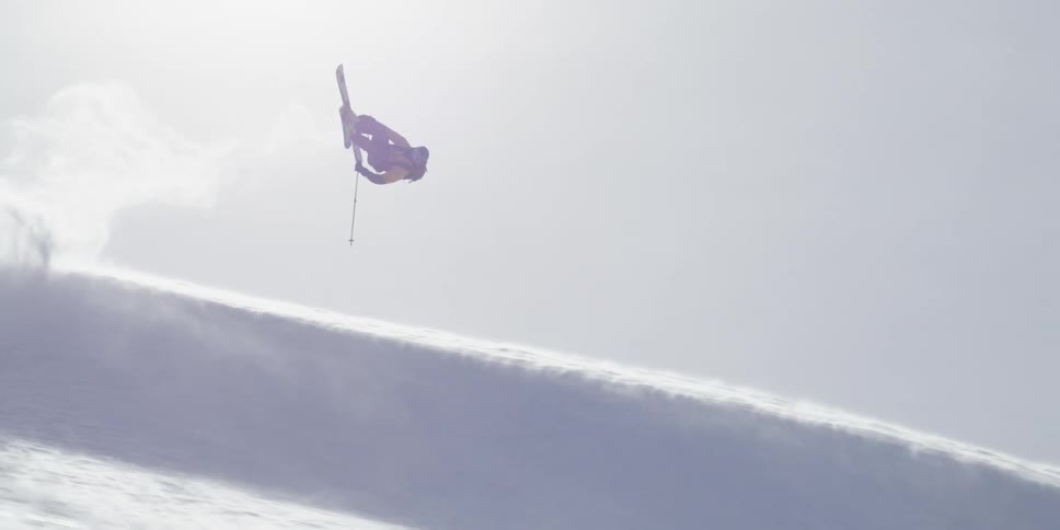 A skier does an impressive jump on a windy slope