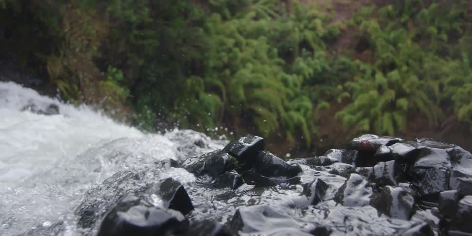 A splashing river flowing over smooth rocks