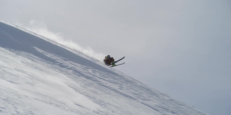 A skier on the mountain does a flip
