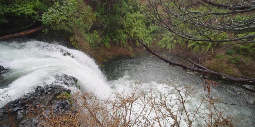 Waterfall flows over the rocks into a lake