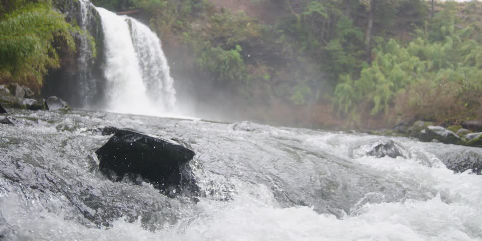 A waterfall crashes down in to a river