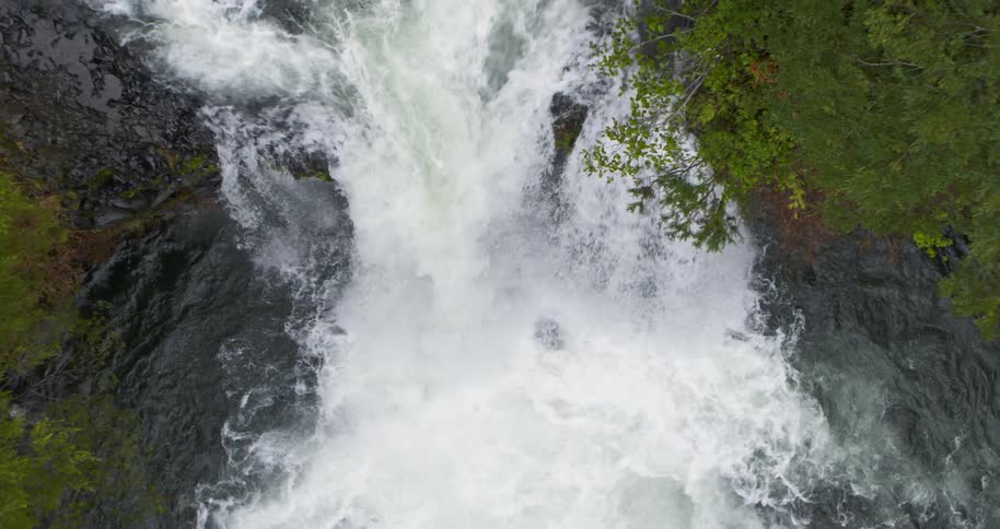 Rising up as water cascades down and splashes into the river below