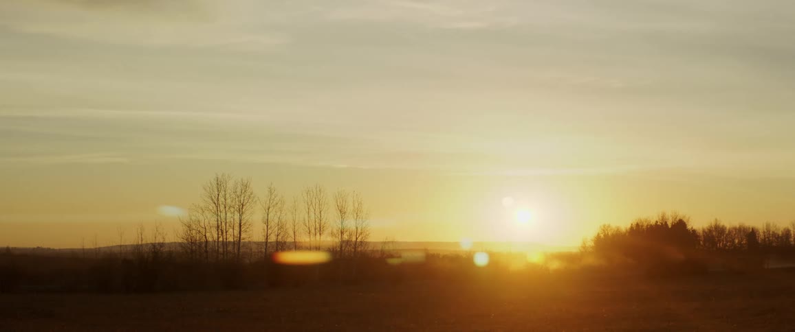 Vehicle travels on the road in the countryside as the sun rises