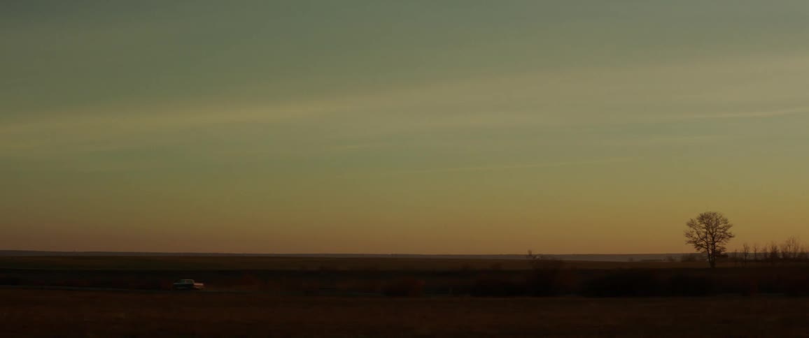 A truck drives along a field