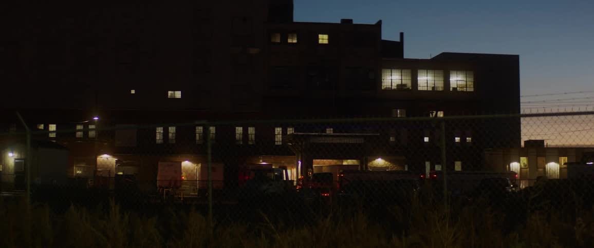Vehicles parked outside an office building at night