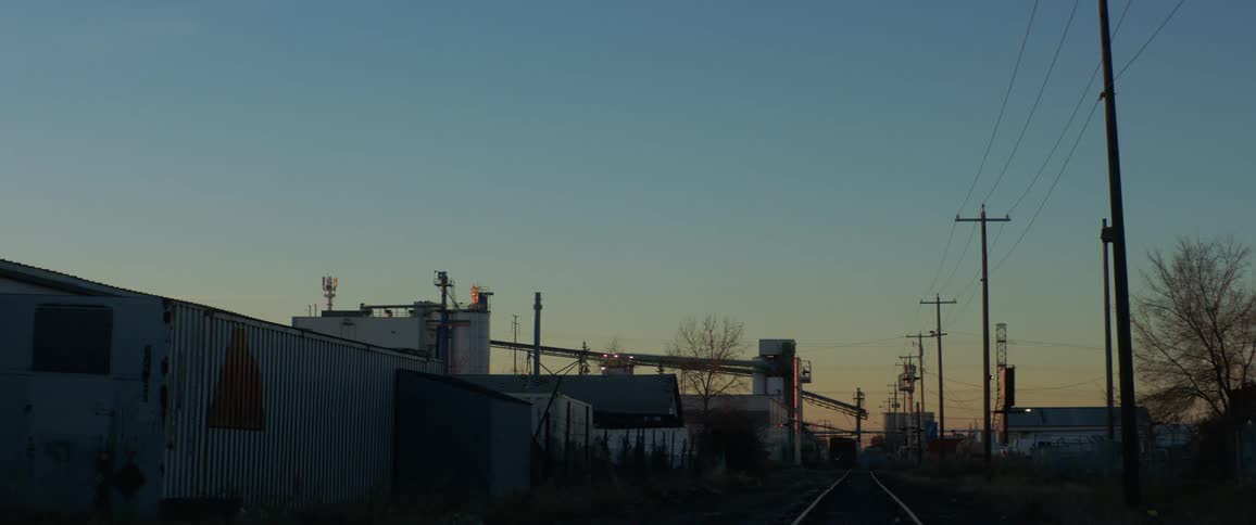 A train track running through a small down during the evening