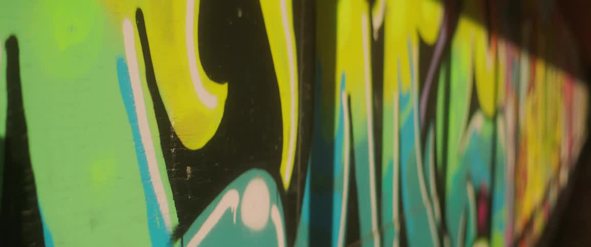 Graffiti covers the wall of a long hallway