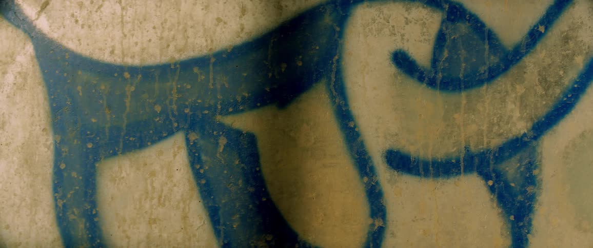 Streaks of dirt cover blue graffiti shape