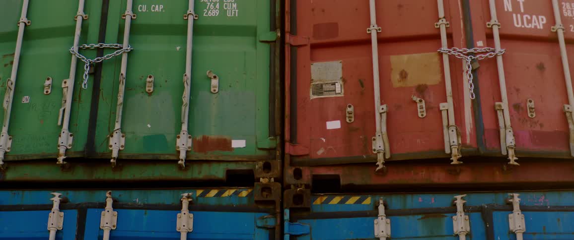 Colorful shipping containers are chained closed and stacked