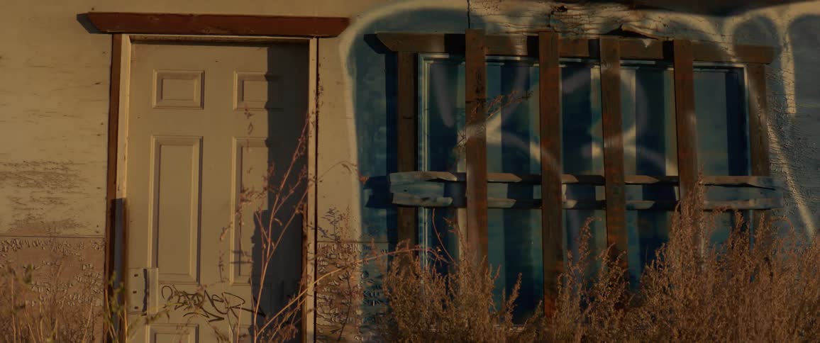 Exterior of abandoned building with barred windows and graffiti