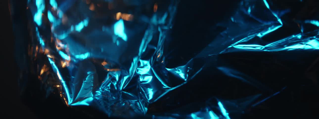 Lights glow and reflect on a wrinkled mylar balloon