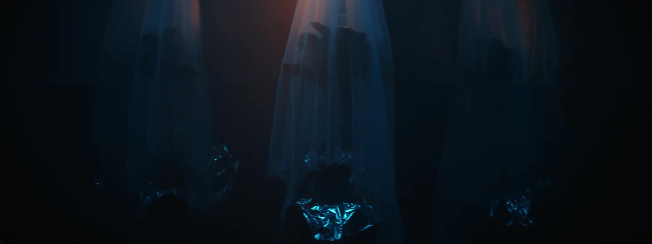 Glowing black objects cause darkness to rise on three item wrapped in veils