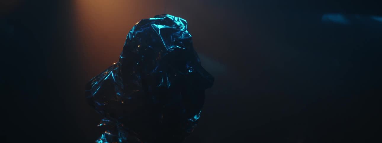 A crumpled foil mylar balloon shimmers in the dark