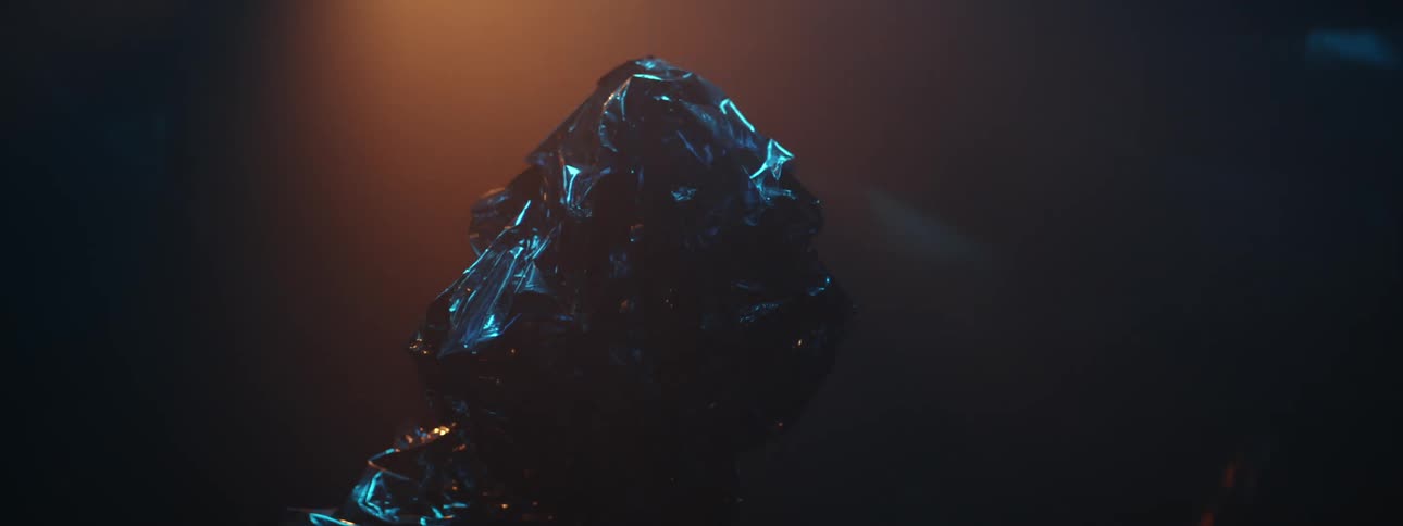 A black wrinkled object with blue color glowing around it