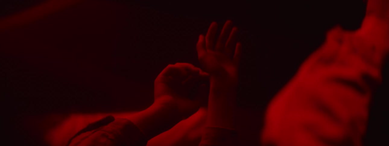 A woman holds her hands up to a mirrored wall