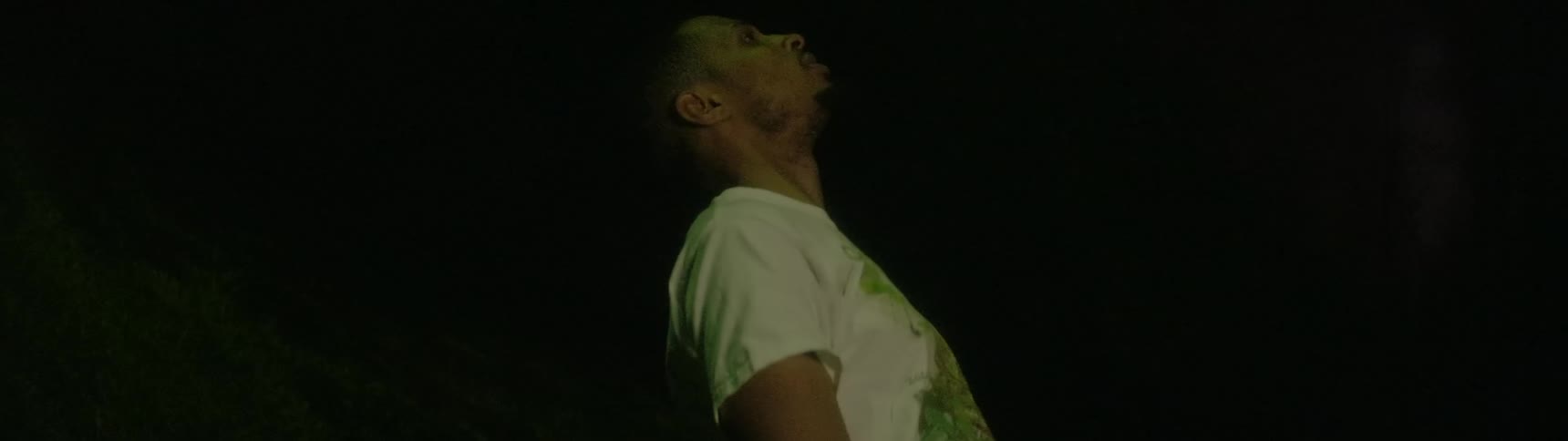 A black man falls backwards in a yard