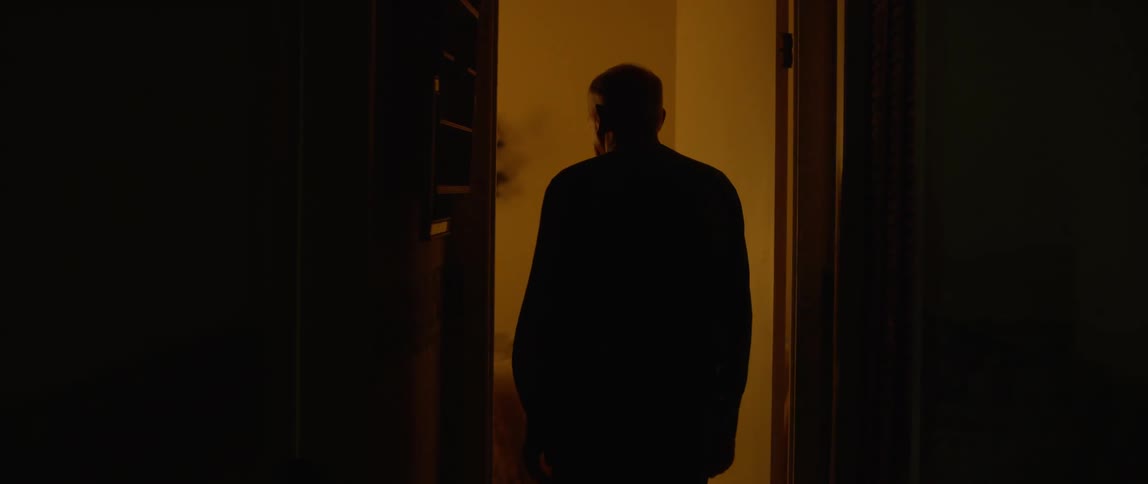A man walks into a room and turns off the lights turning the room black