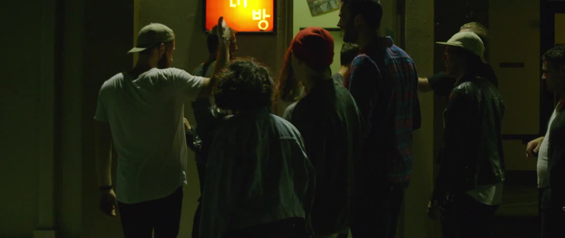 A group of friends laugh as they walk through a building and through a doorway