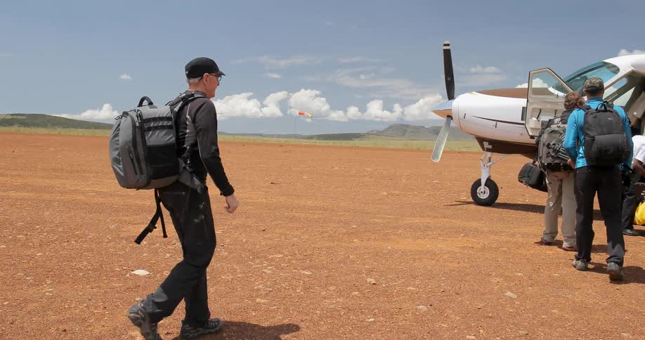 A man walks to a group of people near a plane