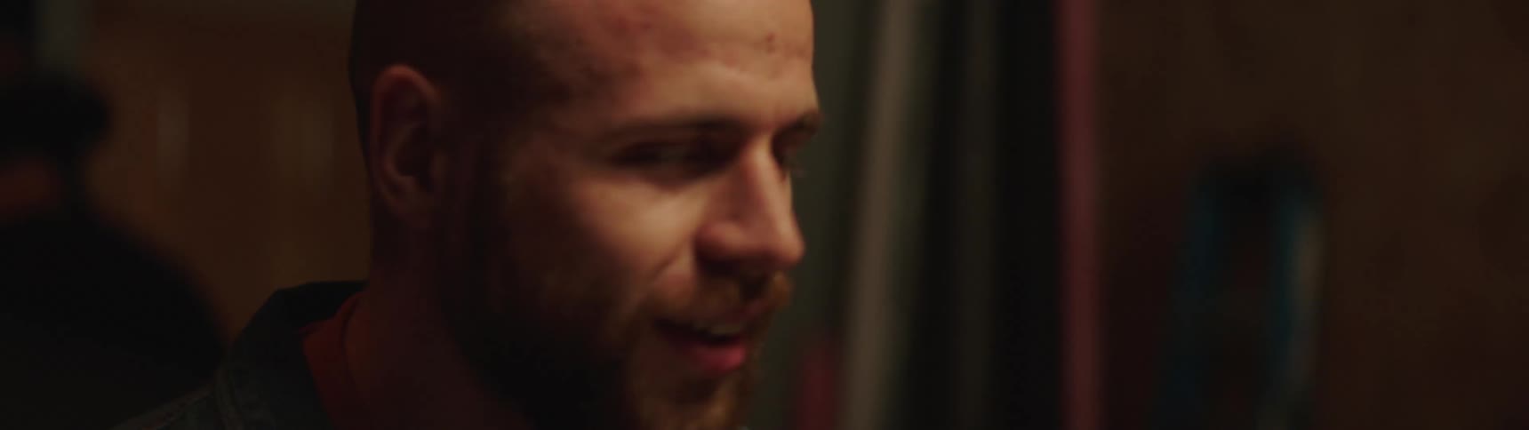 Man talking and smiling in dimly lit room
