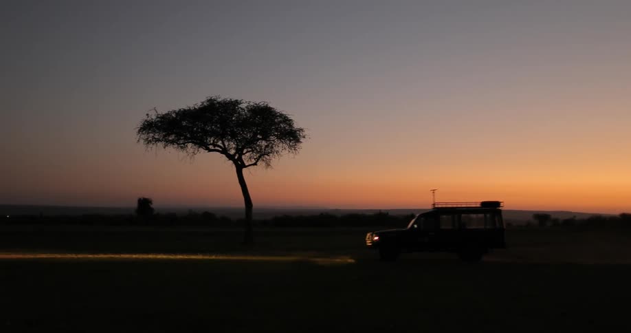 A car drives down a road at sunset