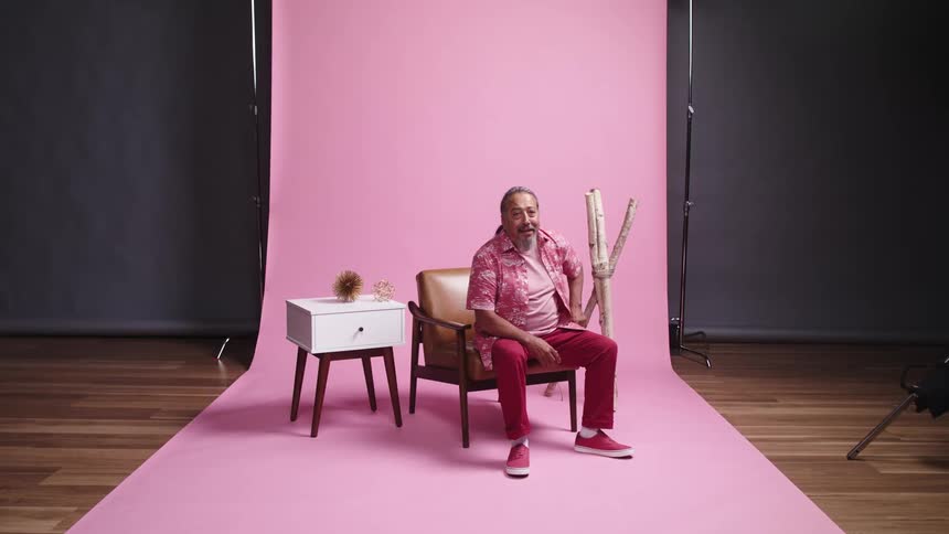 An old man walks over to a chair and sits down in it