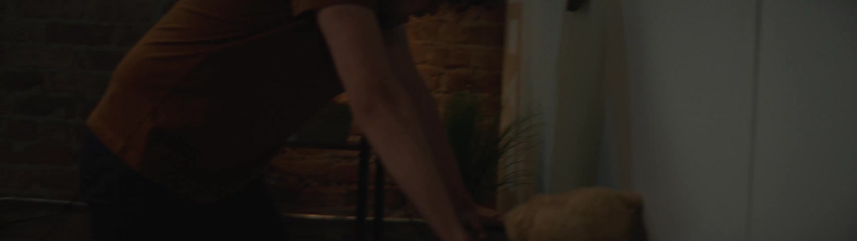 A young man aggressively wipes everything off a table
