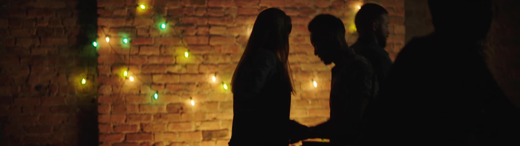 Silhouettes of people dancing at party