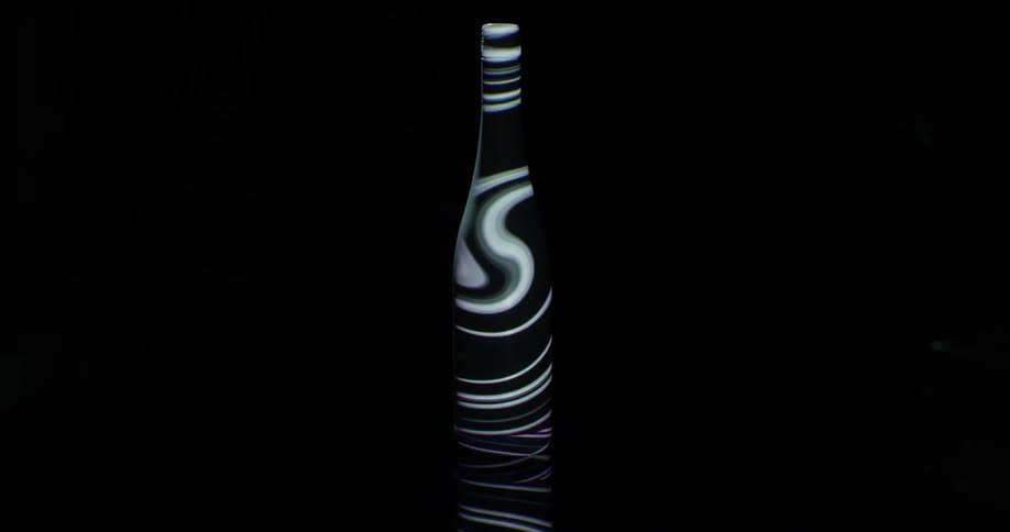 A bottle with swirls projected on it